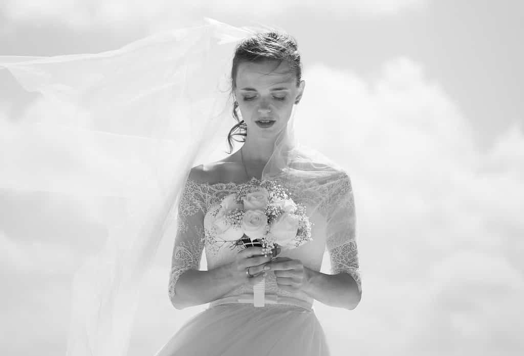 grayscale picture of bride holding flower bouquet